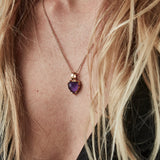 Amethyst love claw necklace being worn by woman with long blonde hair and black top