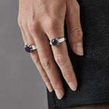 Amethyst ring being worn on index finger of woman's hand.
