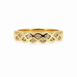 A yellow gold band ring featuring a wavy, braided pattern with small clear gemstones set along the front, shown on a plain white background.